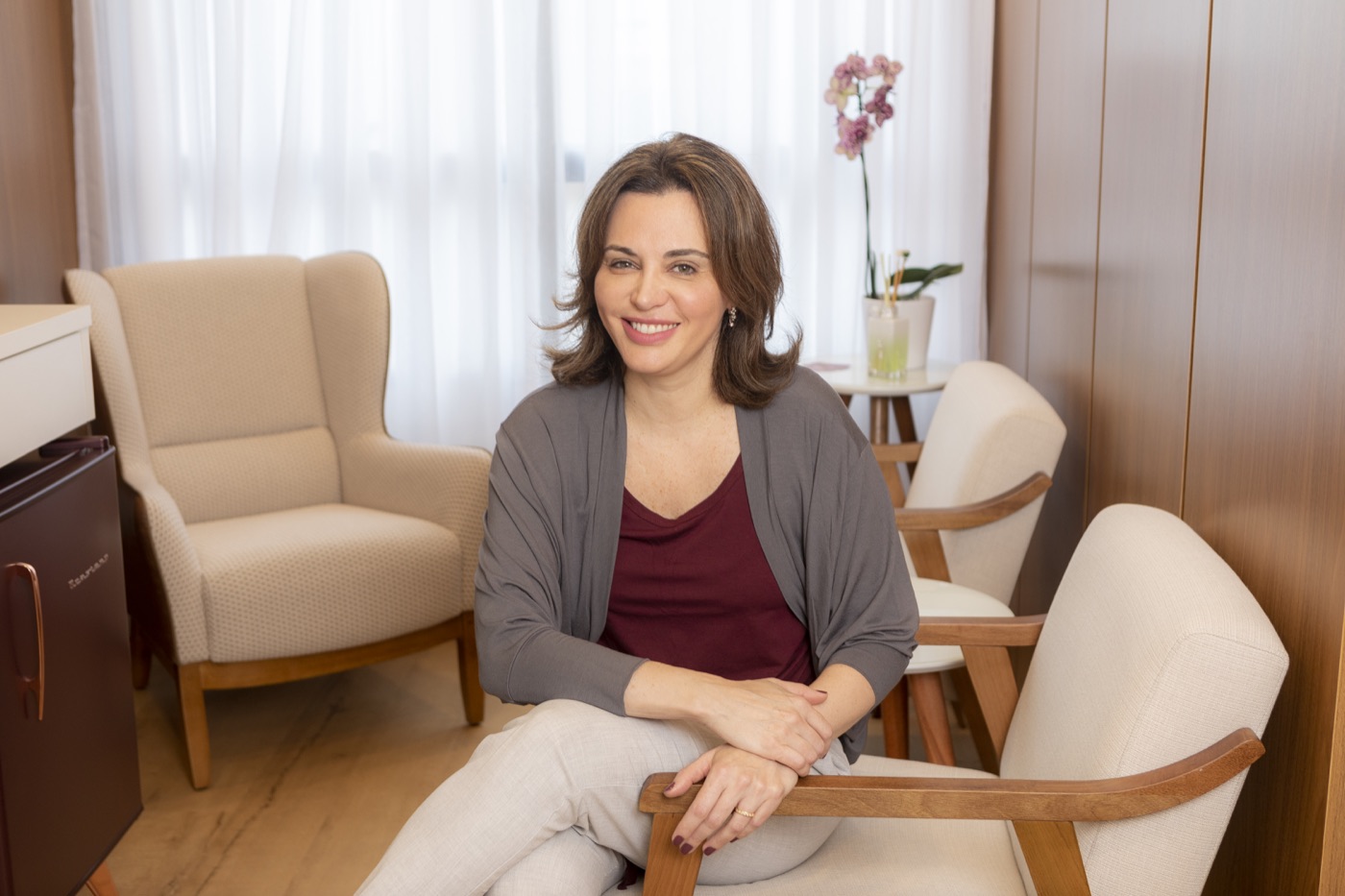 Dr. Lara Lavin smiling in the reception area of her practice in Itaim Bibi